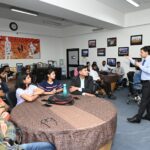 A wide shot of the JIM Auditorium, filled with attentive students, focused on Rohin Koul as he shares his experiences and expertise in e-commerce.