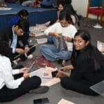 MBA students from Jaipuria Institute of Management working intently on their design projects, demonstrating teamwork and creativity in a design thinking workshop.