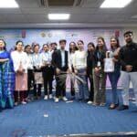 A group of students and faculty members standing with their innovative product designs at Jaipuria Institute of Management, showcasing the outcome of the design event.