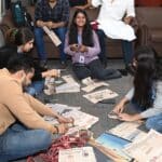 Concentrated groups of students collaborating on innovative product design projects in a lively workshop environment at Jaipuria Institute of Management.