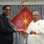 Daviender Narang receiving a token of appreciation from a spiritual leader at the Brahma Kumaris event.