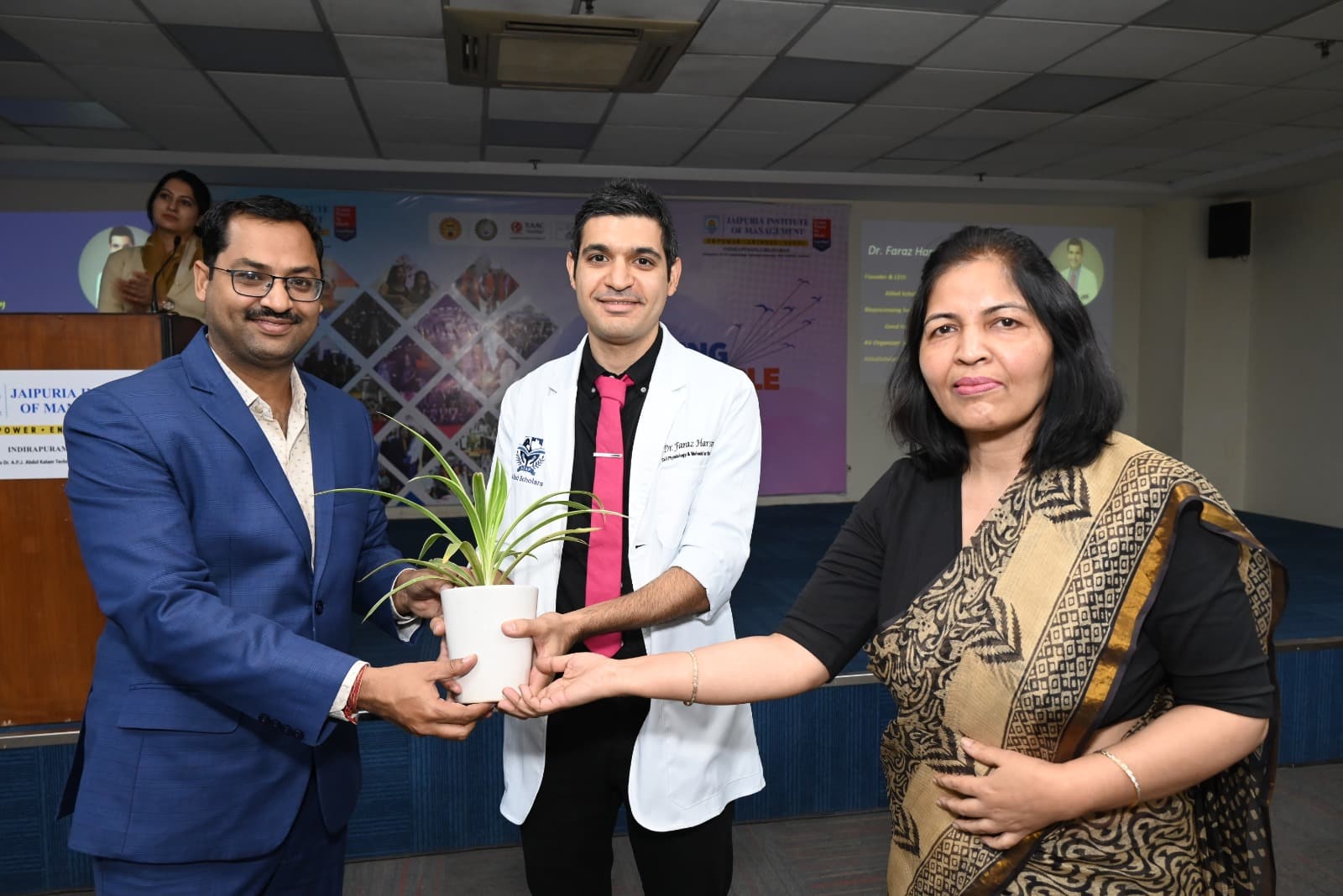 Dr. Faraz Harsini receiving a plant as a token of appreciation for his contributions to sustainability at the Jaipuria Institute of Management.