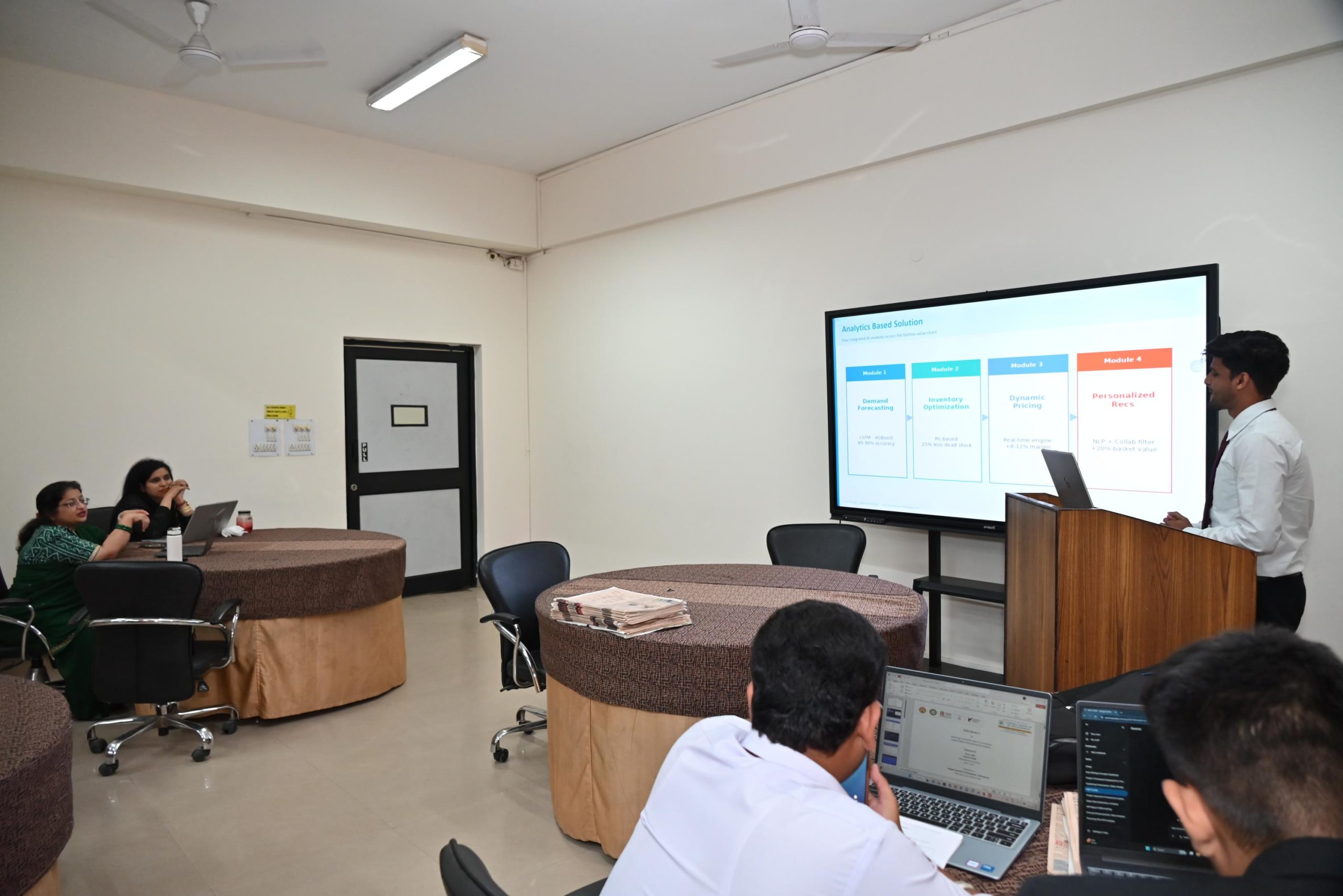 Workshop on Protecting IPR and IP Management for Startups 2026 6 - Jaipuria Institute of Management, Indirapuram Ghaziabad Man presenting a slide deck on a large screen to a group of people with laptops in a conference room.