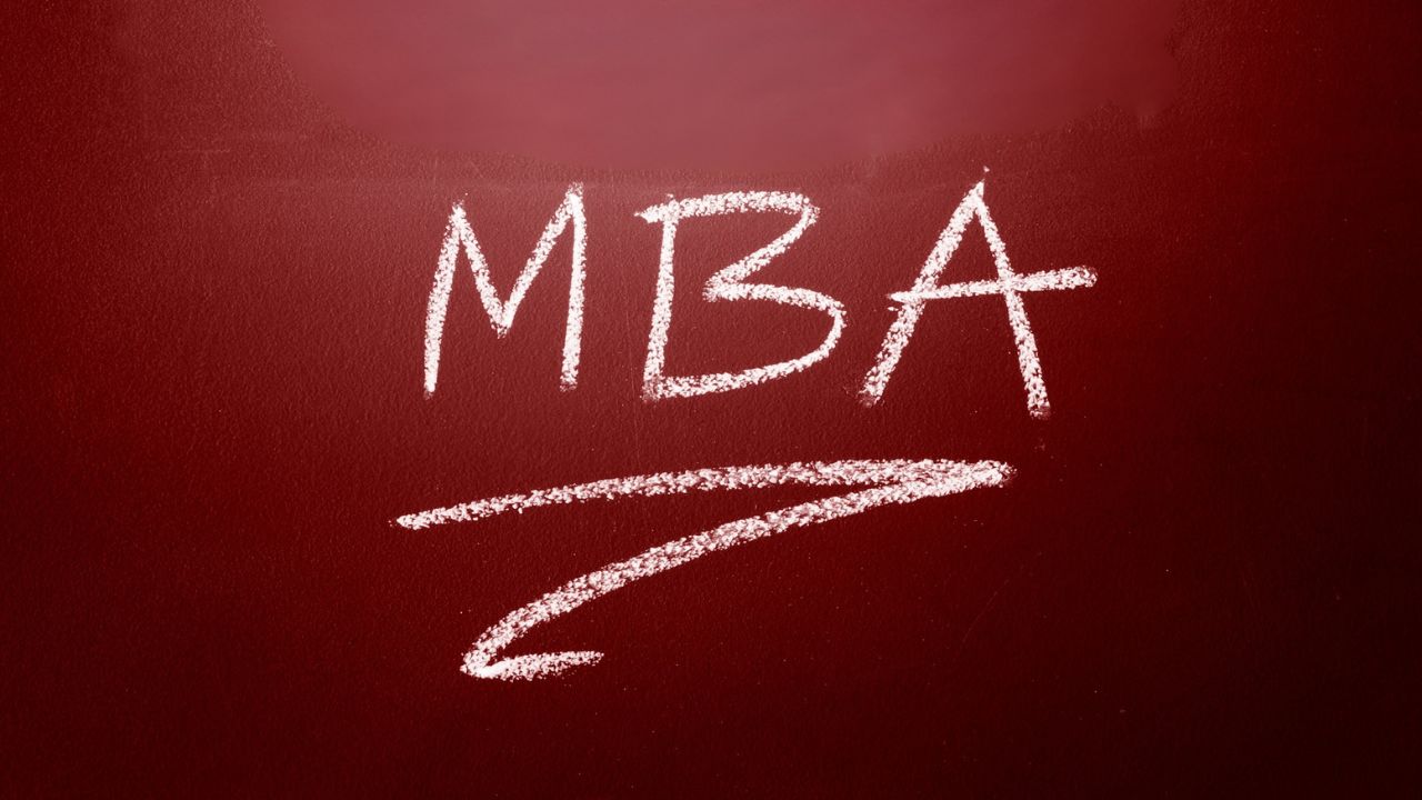 Red chalkboard with the white letters 'MBA' and a curved underline arrow drawn in chalk.