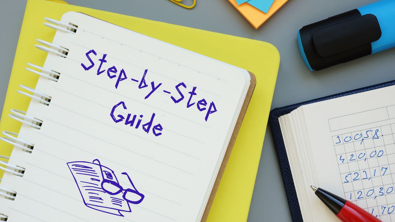 Notebook page titled 'Step-by-Step Guide' with a glasses doodle, on a yellow binder among desk supplies.
