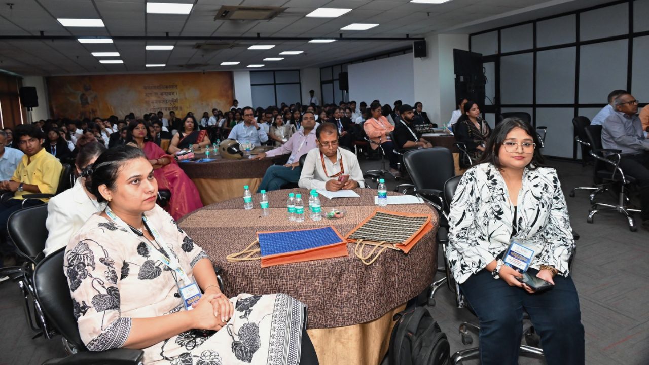AIM-PEACE 2026_ International AI Conference at Jaipuria MBA 11 - Jaipuria Institute of Management, Indirapuram Ghaziabad Conference room full of attendees; two women sit at a round table in the foreground with water bottles and folders nearby.