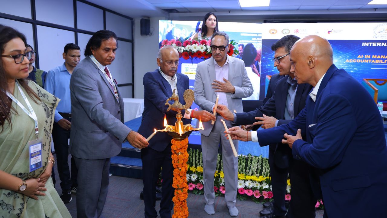 AIM-PEACE 2026_ International AI Conference at Jaipuria MBA 2 - Jaipuria Institute of Management, Indirapuram Ghaziabad Group of professionals lighting a ceremonial lamp at an event, with a marigold lamp and flower decorations nearby.