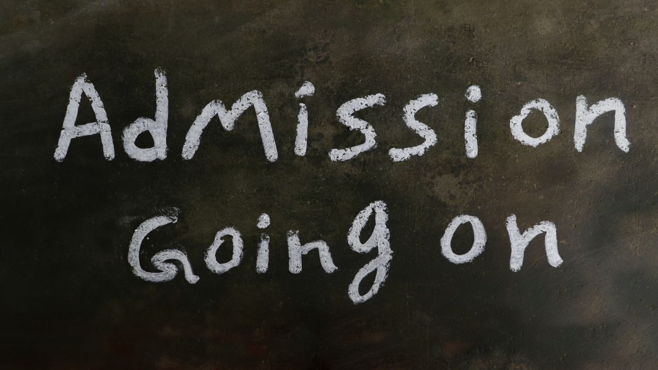 Chalkboard sign reading 'Admission Going on' in white chalk on a dark background.