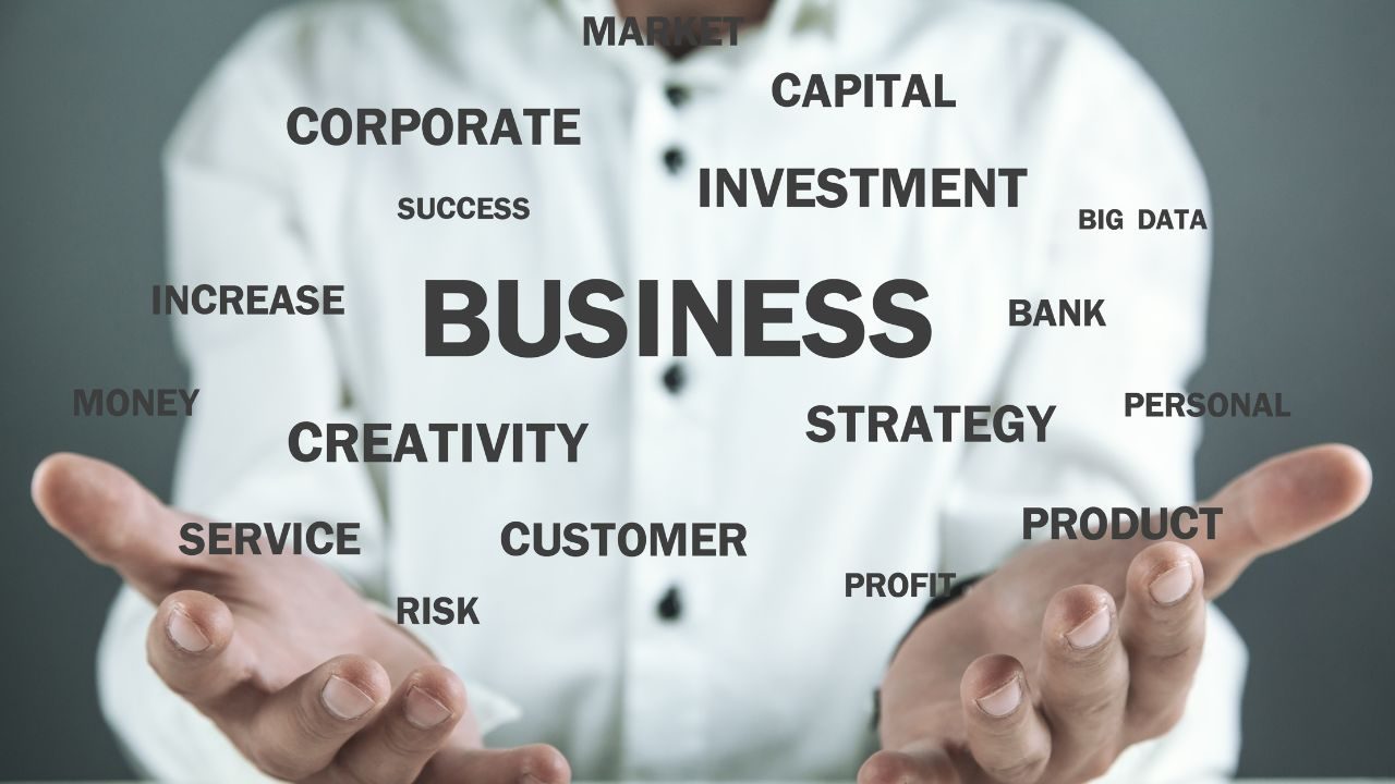 Outstretched hands beneath floating business terms like BUSINESS, STRATEGY, INVESTMENT, and SUCCESS, suggesting business ideas and support.