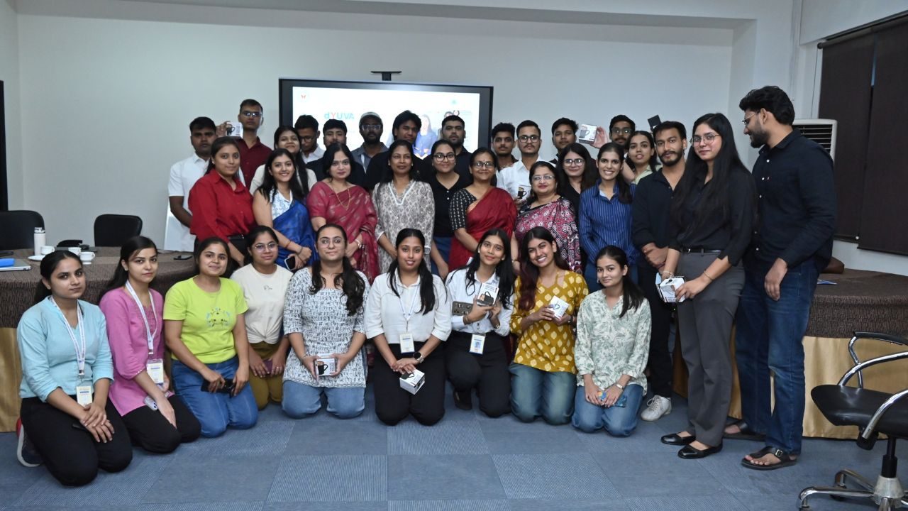 Group of colleagues posing for a photo in a conference room, many wearing lanyards and badges.
