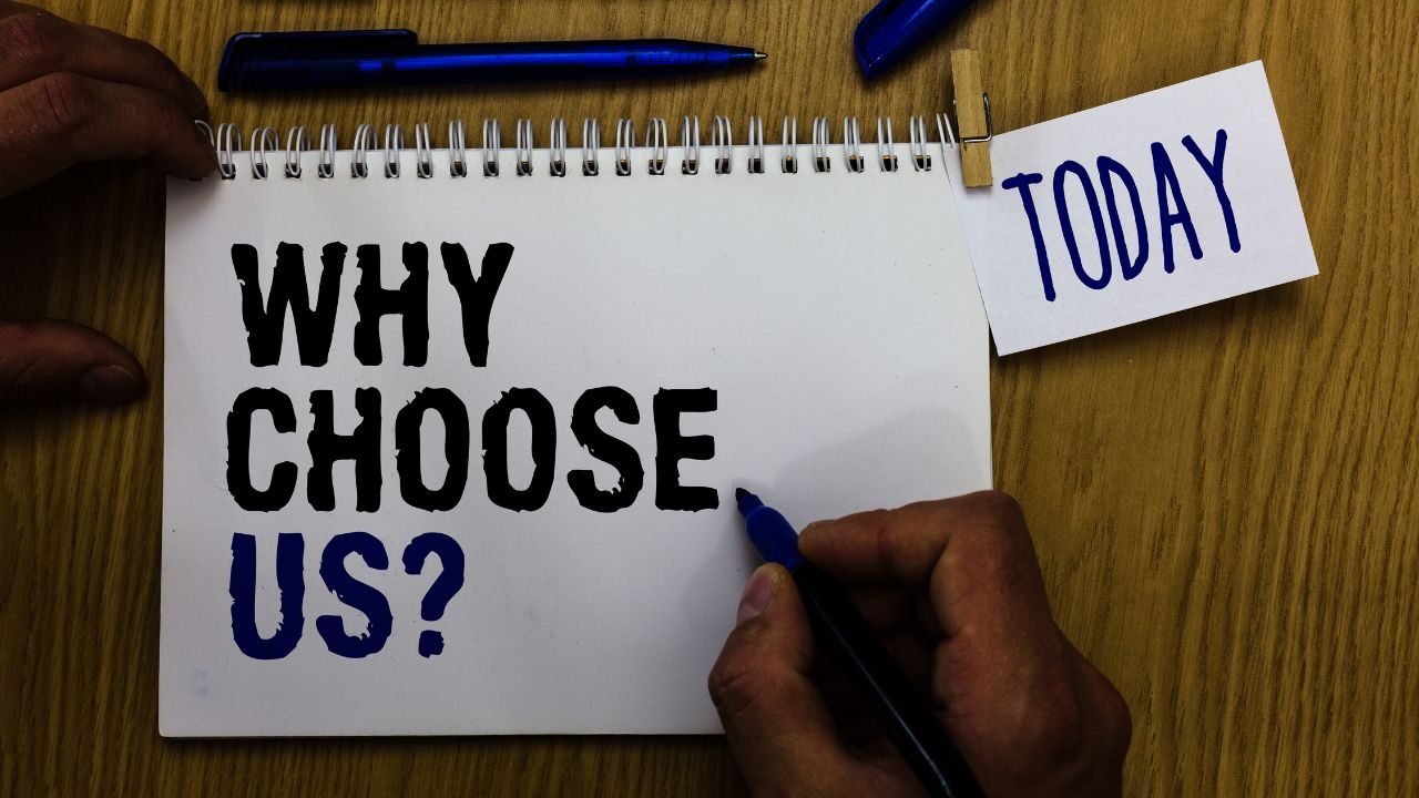 Notebook page asks 'Why Choose Us?' with a blue marker being written, on a wooden table beside a 'Today' card clipped nearby.